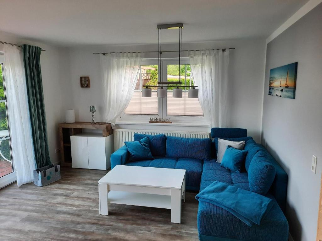 a living room with a blue couch and a table at Ferienwohnung Finja - a70682 in Dreschvitz
