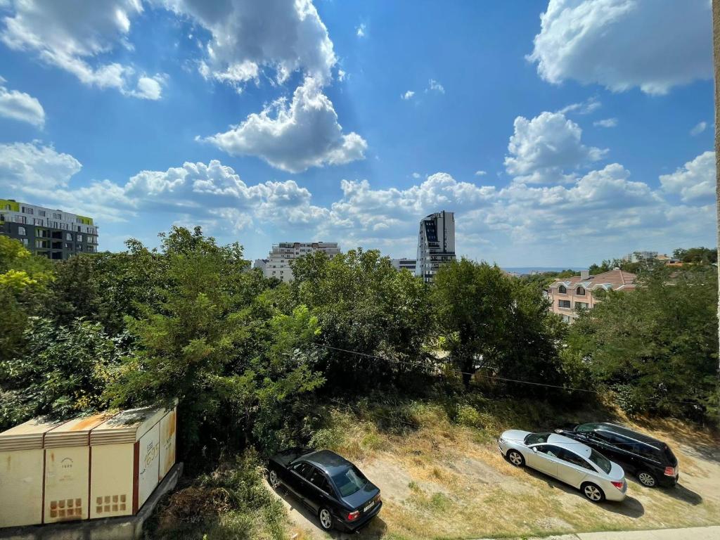 two cars parked in a parking lot in a city at Apartment Sanik in Varna City