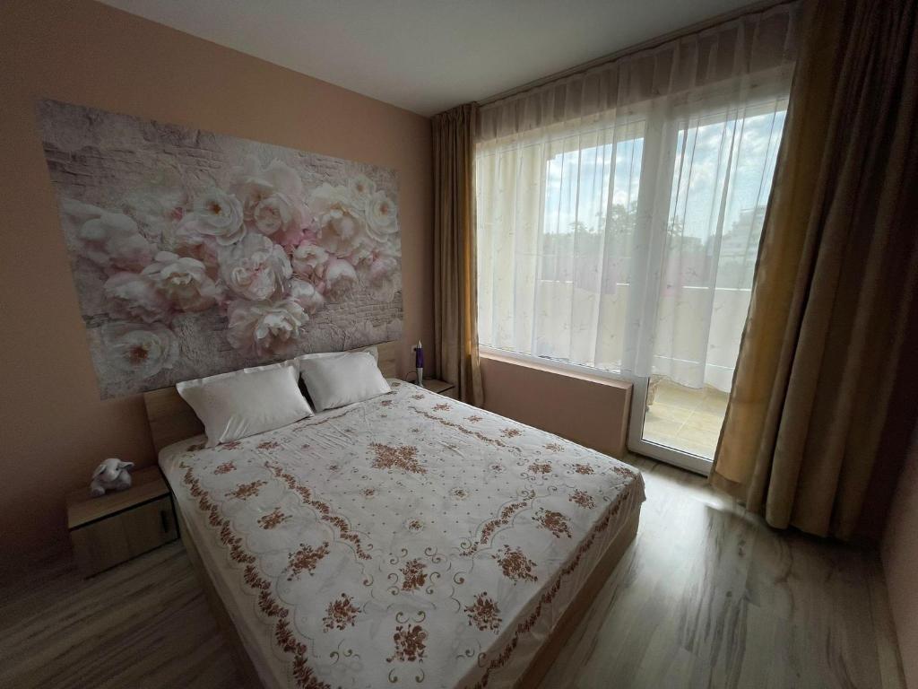 a bedroom with a bed with a painting on the wall at Apartment Sanik in Varna City