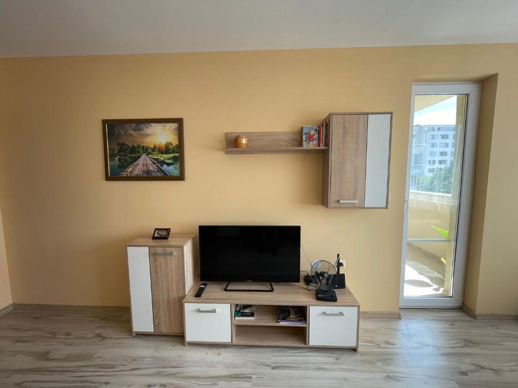 a living room with a tv and a desk at Apartment Sanik in Varna City