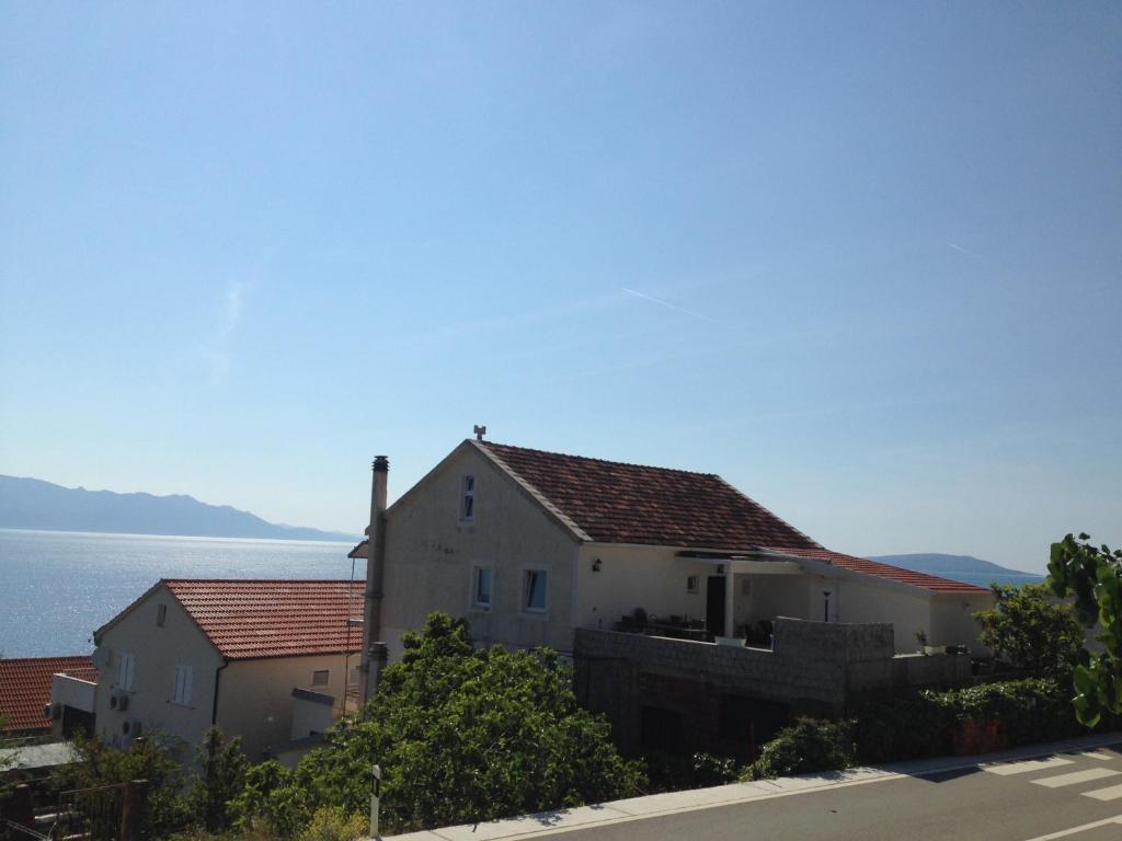 a house on a hill with the ocean in the background at Apartments by the sea Brist, Makarska - 13011 in Podaca