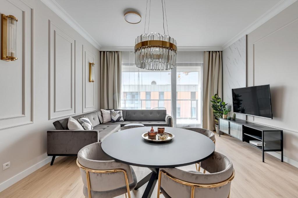 a living room with a table and a couch at Grand Apartments - Brabank Apartments in Gdańsk