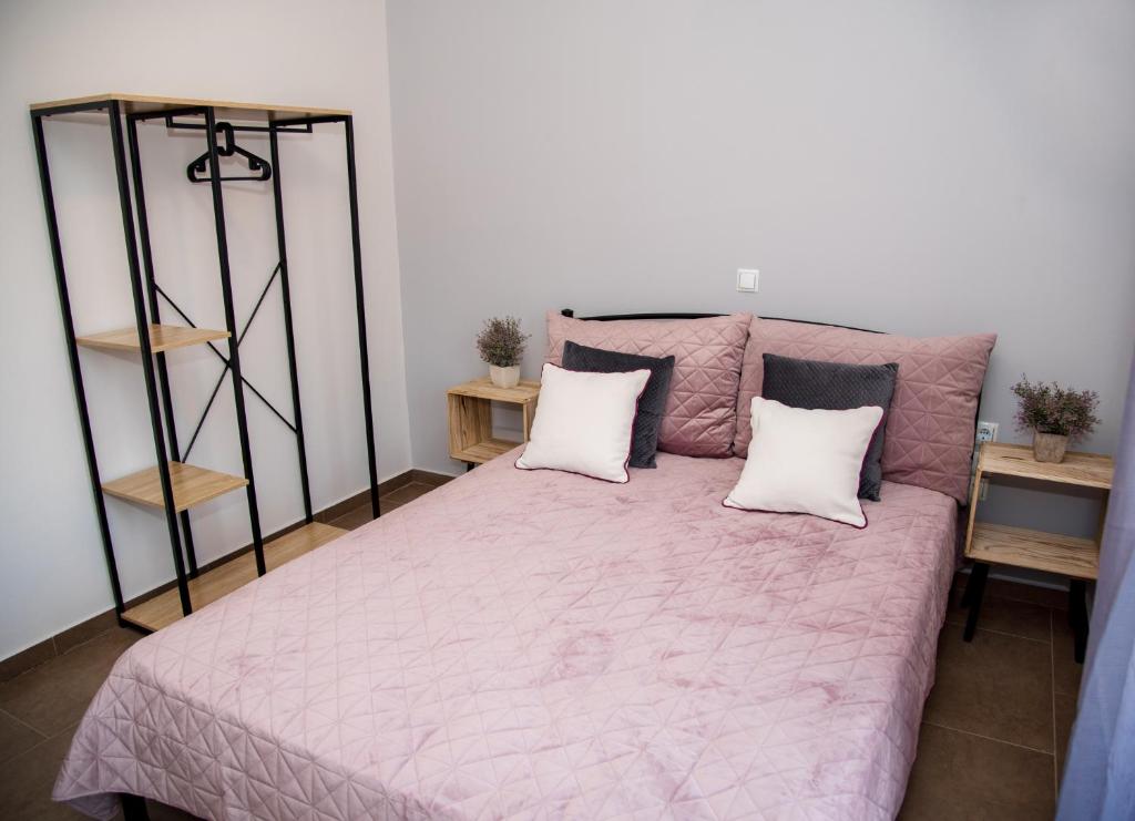 um quarto com uma cama rosa e 2 almofadas em Nikolas Apartment em Alexandroupoli