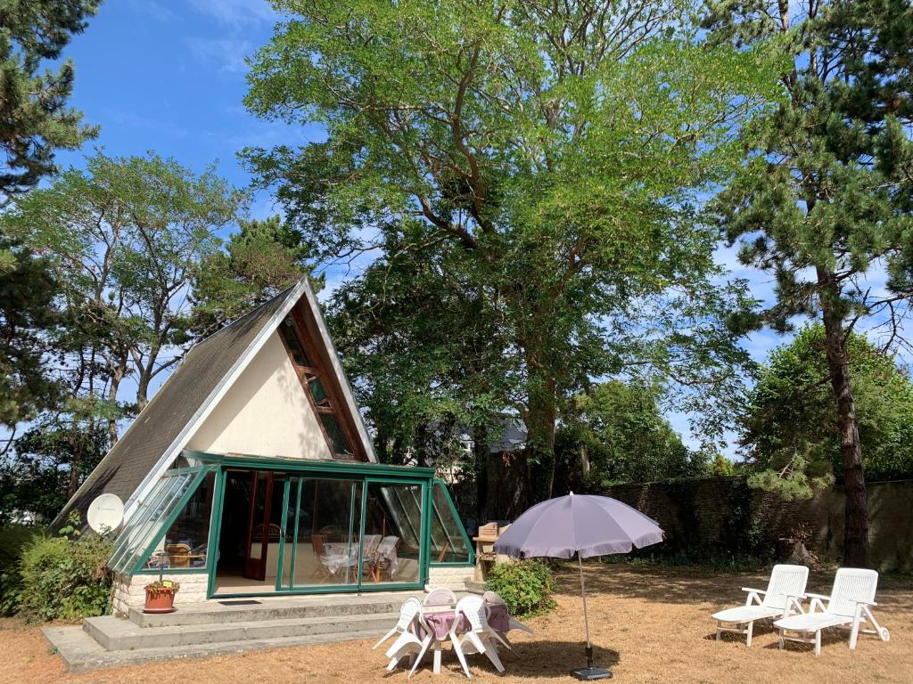 une tente avec des chaises et un parasol devant elle dans l'établissement Chalet de vacances au bord de mer VER SUR MER, à Ver-sur-Mer