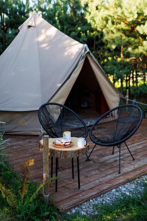 2 sillas y una mesa frente a una tienda en Glamping - Projekt Alpaka, en Garbatka-Letnisko