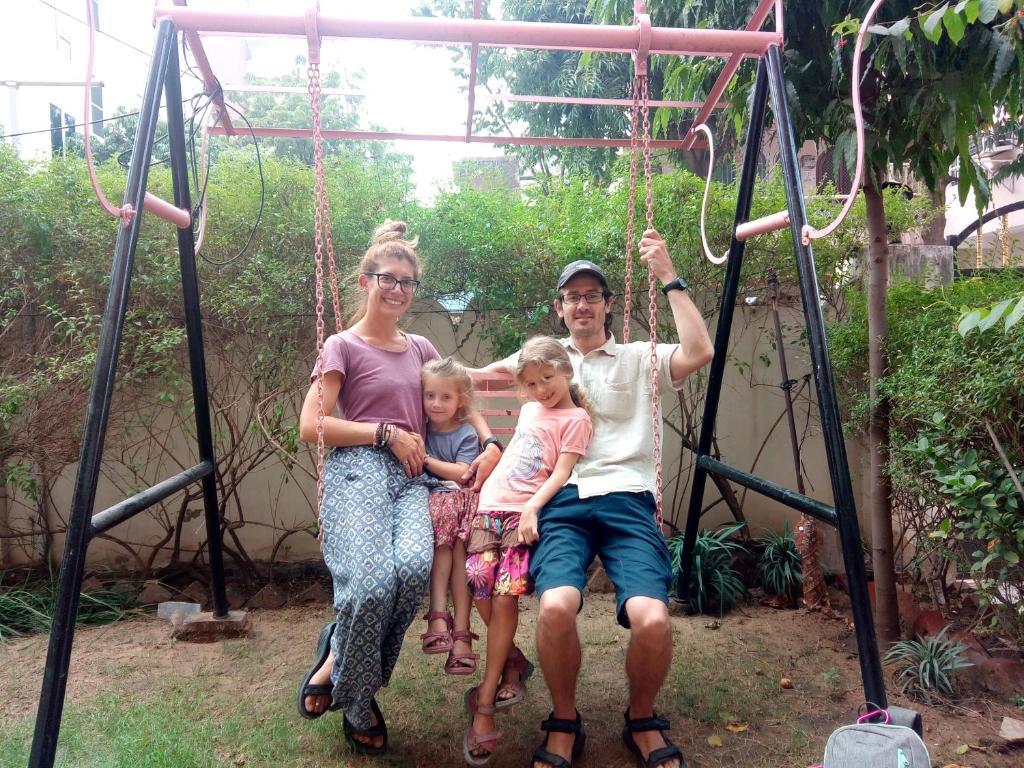 a group of three people sitting on a swing at Jwala Niketan Guesthouse Private rooms in Jaipur