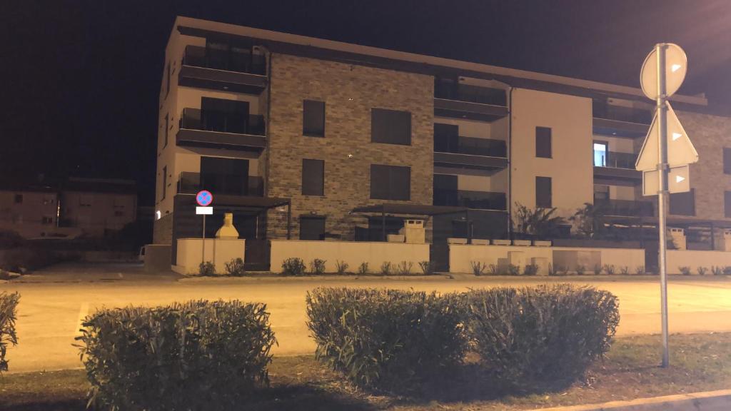 een gebouw 's nachts met struiken ervoor bij Apartment Petrovic Medulin in Medulin