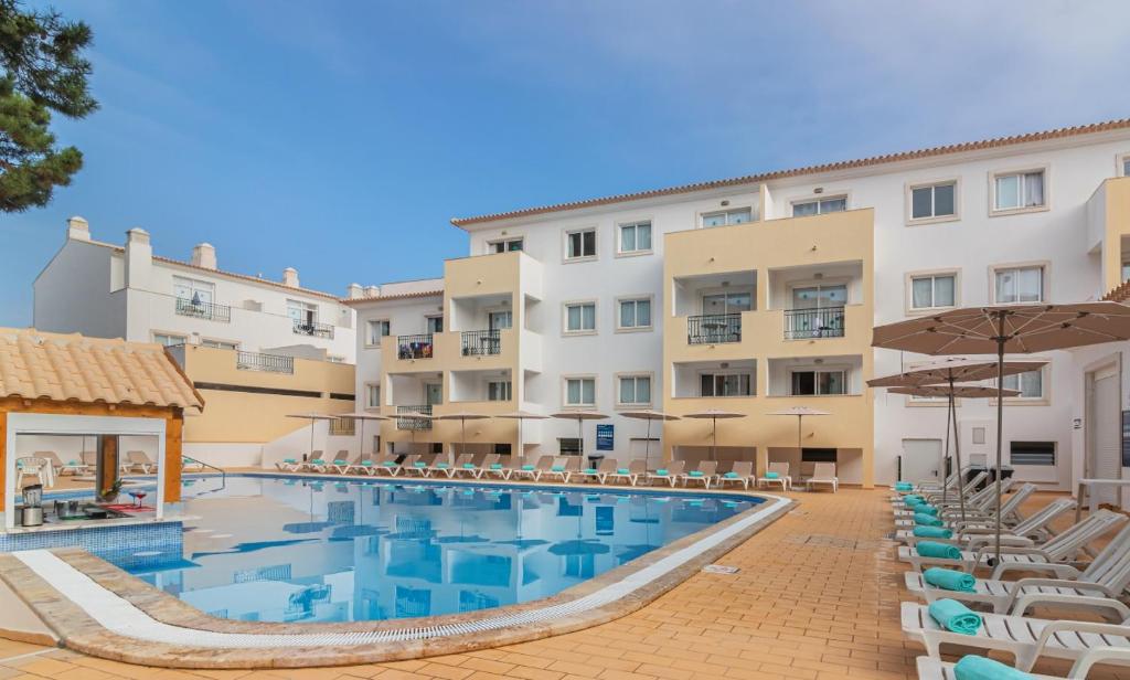 アルブフェイラにあるSmy Santa Eulalia Algarveのプールと椅子が備わるホテルの景色を望めます。