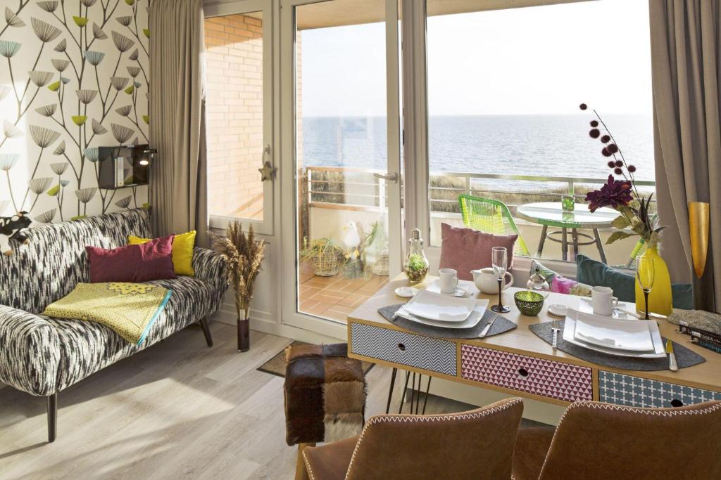 a living room with a table and a view of the ocean at Lieblingsblick in List