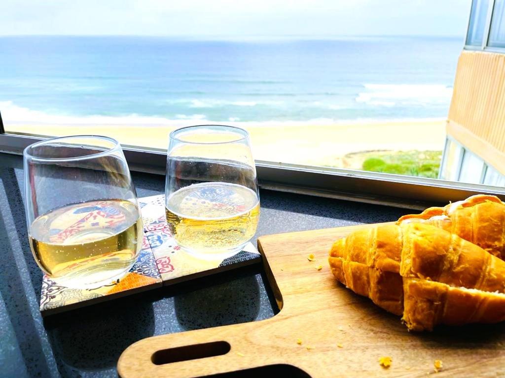 a table with two glasses and a cutting board with bread at Mai Paradise in Kingsburgh