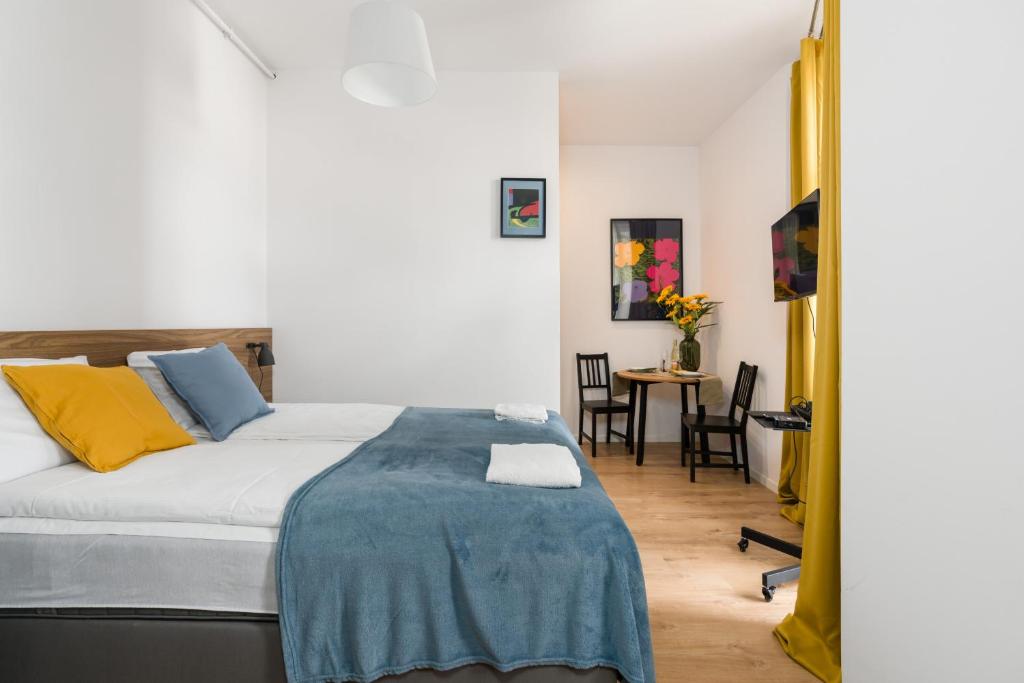a bedroom with a bed and a table with chairs at Kwiatowa Apartments Poznań City Center by Renters in Poznań