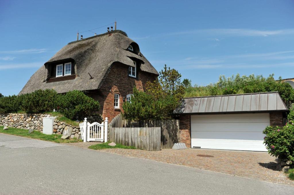 uma casa com telhado de palha e uma garagem em Senenskiin em List