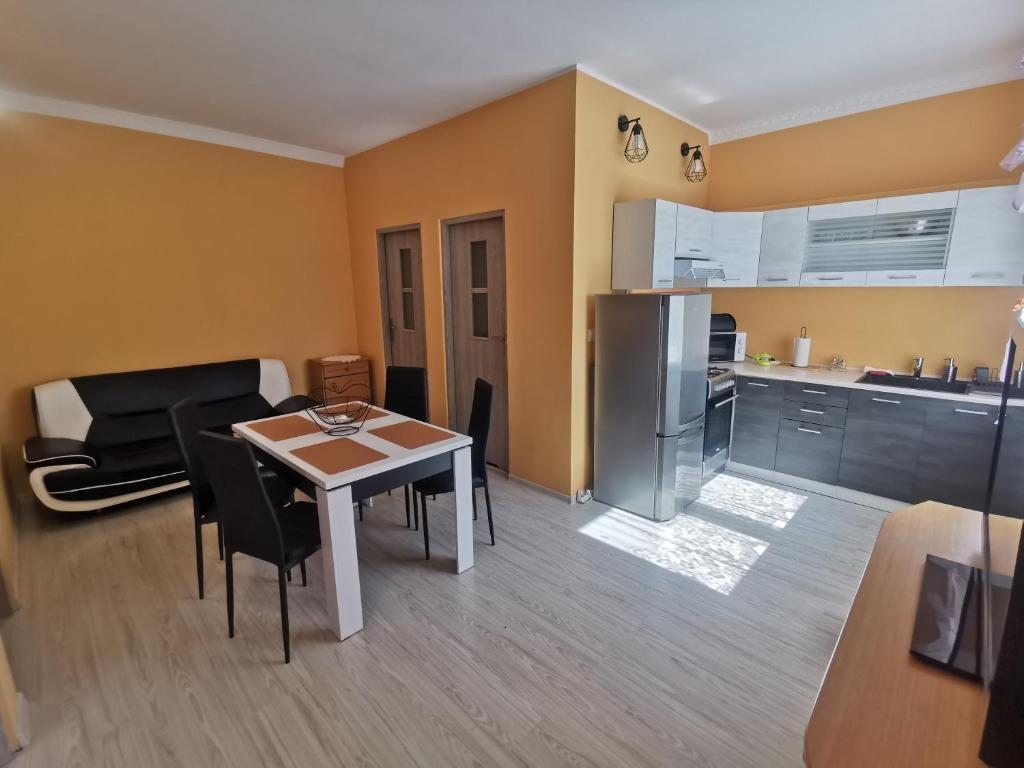 Una cocina y una sala de estar con mesa y sillas. en Przystań Familijna, en Santoczno