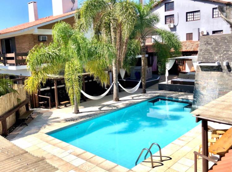 里奧格蘭德的住宿－Lira Hotel & Restaurante，大楼前带吊床的游泳池