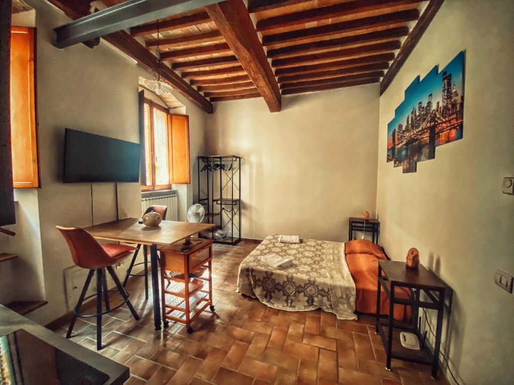 um quarto com uma cama e uma mesa num quarto em La Casina MAG em Pienza