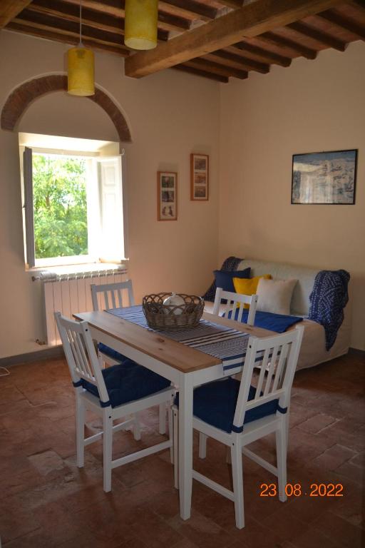 una sala da pranzo con tavolo, sedie e divano di La casa di Agata a Guardistallo