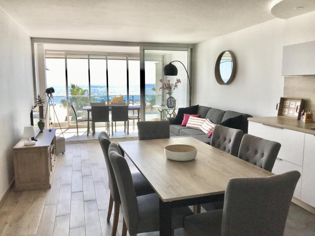 cocina y sala de estar con mesa y sillas en Appartement face à la mer - 6 à 8 personnes - Canet en Roussillon, en Canet-en-Roussillon