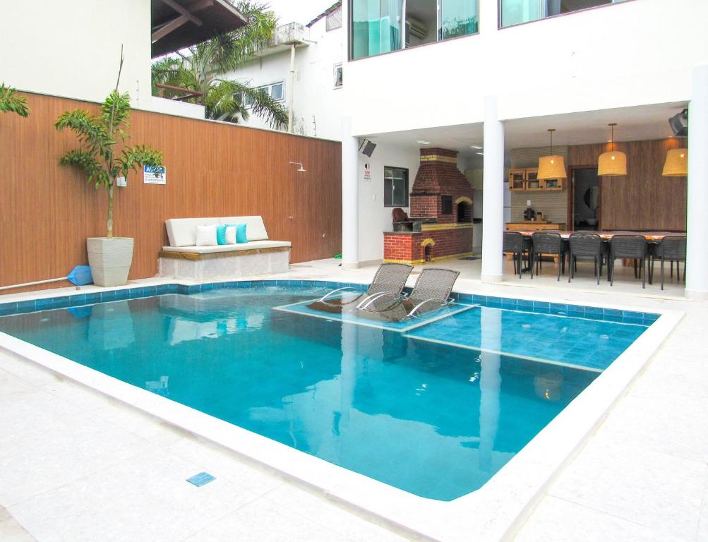 uma piscina com duas cadeiras e uma casa em Apto c piscina e WiFi a 150m da Praia de Mundaí - BA em Porto Seguro