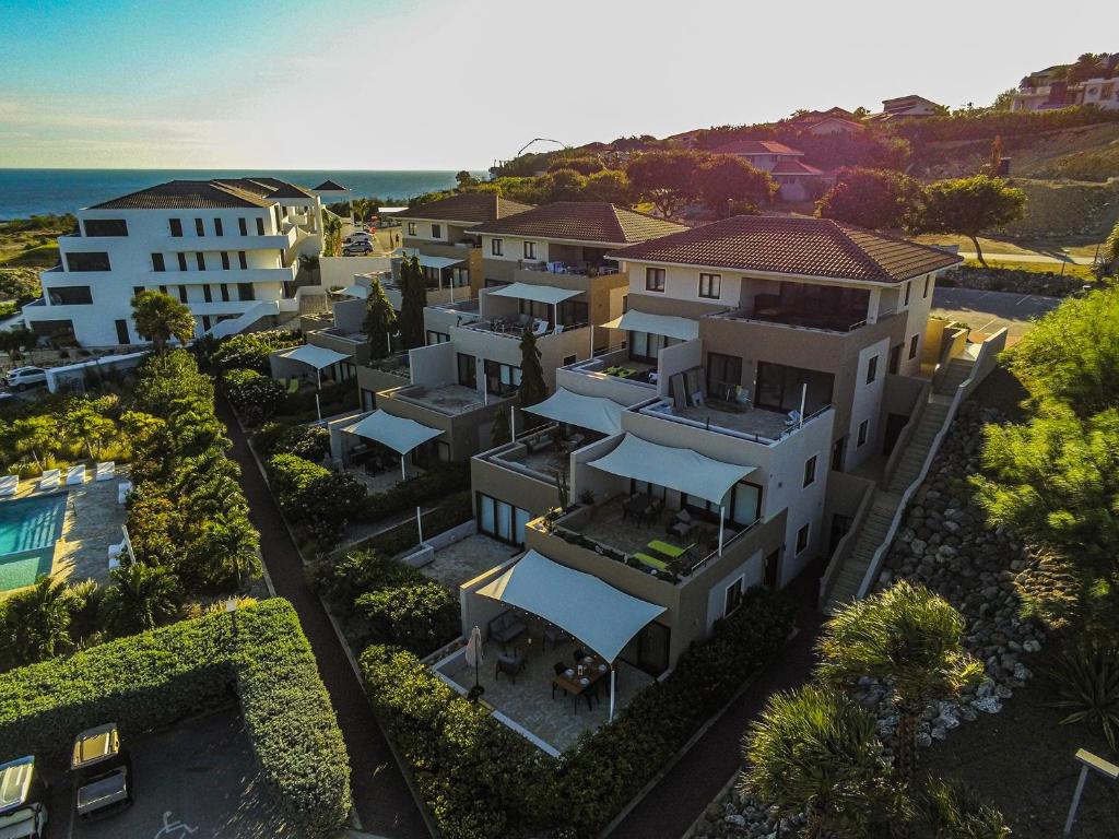 een luchtzicht op een gebouw met uitzicht op de oceaan bij Blauw Geluk in Blauw Baai