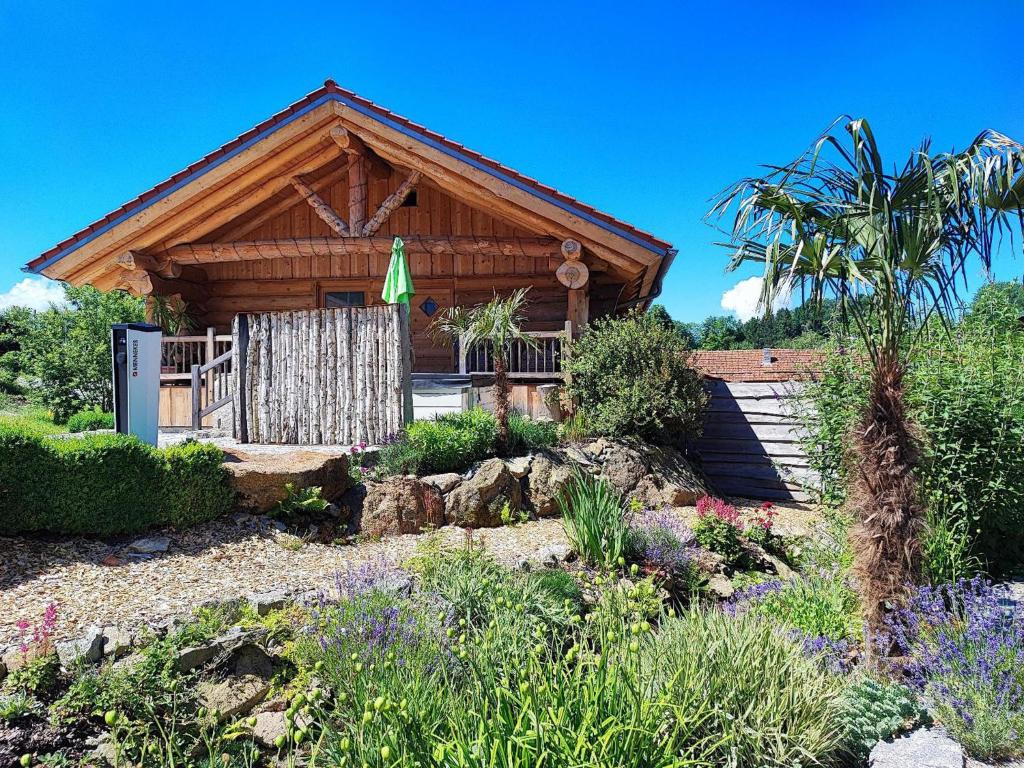 una cabaña de madera con un jardín frente a ella en Willis Hütte, en Zachenberg