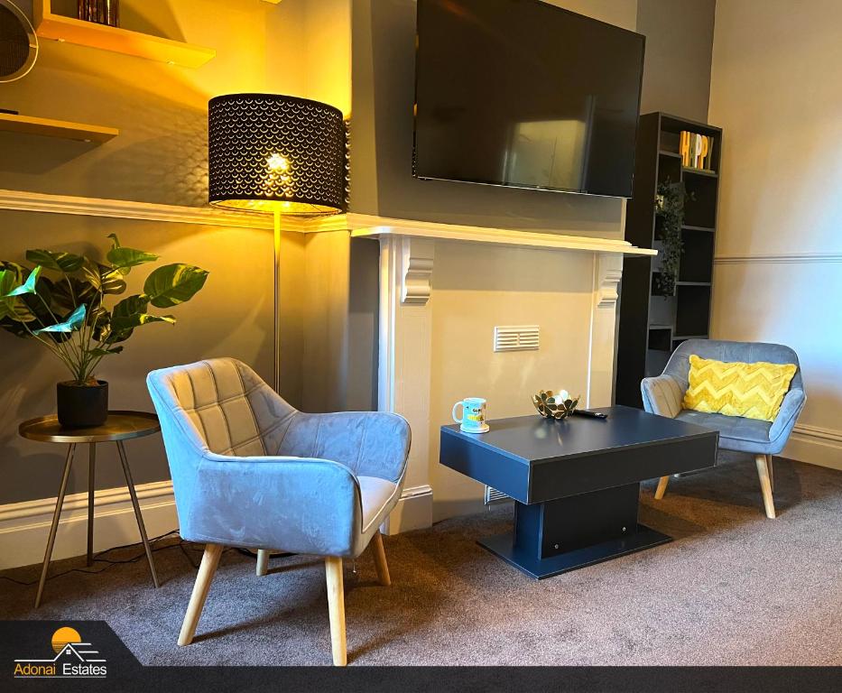 a living room with two chairs and a table at Priorswood House in Taunton