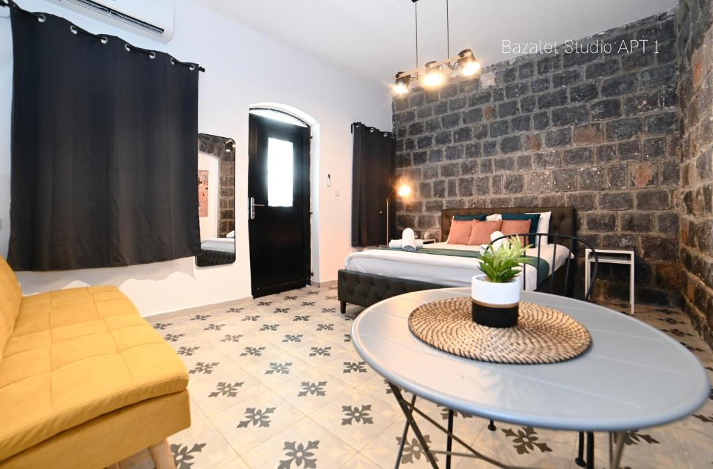 Cette chambre comprend un lit, une table et un canapé. dans l'établissement Puy Bazelet Apartments, à Tibériade