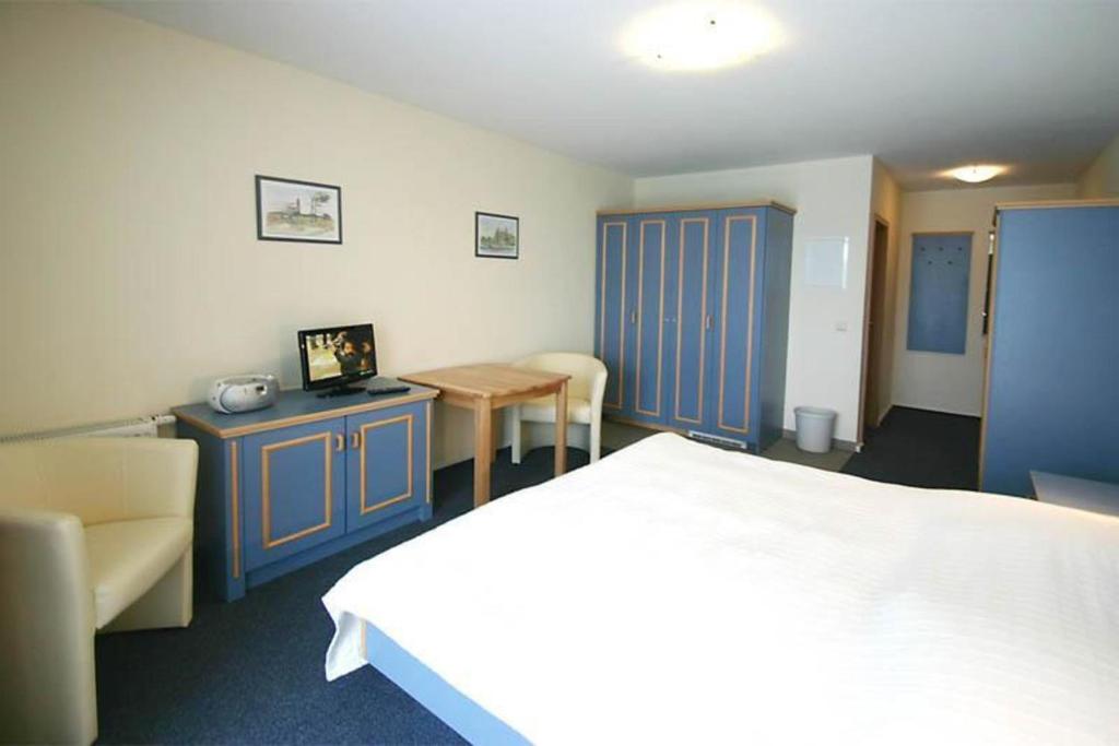 una camera d'albergo con letto, tavolo e sedie di Yachthafenresidenz-Wohnung-6205-832 a Kühlungsborn