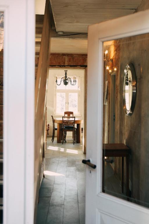 a hallway leading to a dining room with a table at Kalnciema kvartāla Kuldīgas rezidence in Kuldīga