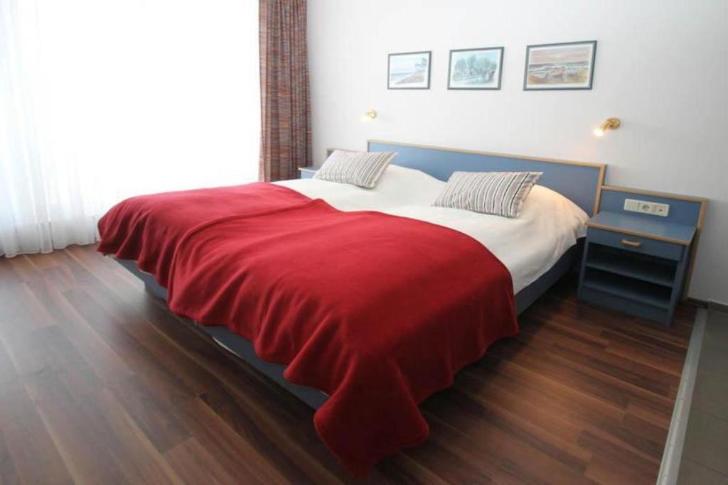 キュールングスボルンにあるYachthafenresidenz-Wohnung-9203-894のベッドルーム1室(赤毛布付きの大型ベッド1台付)