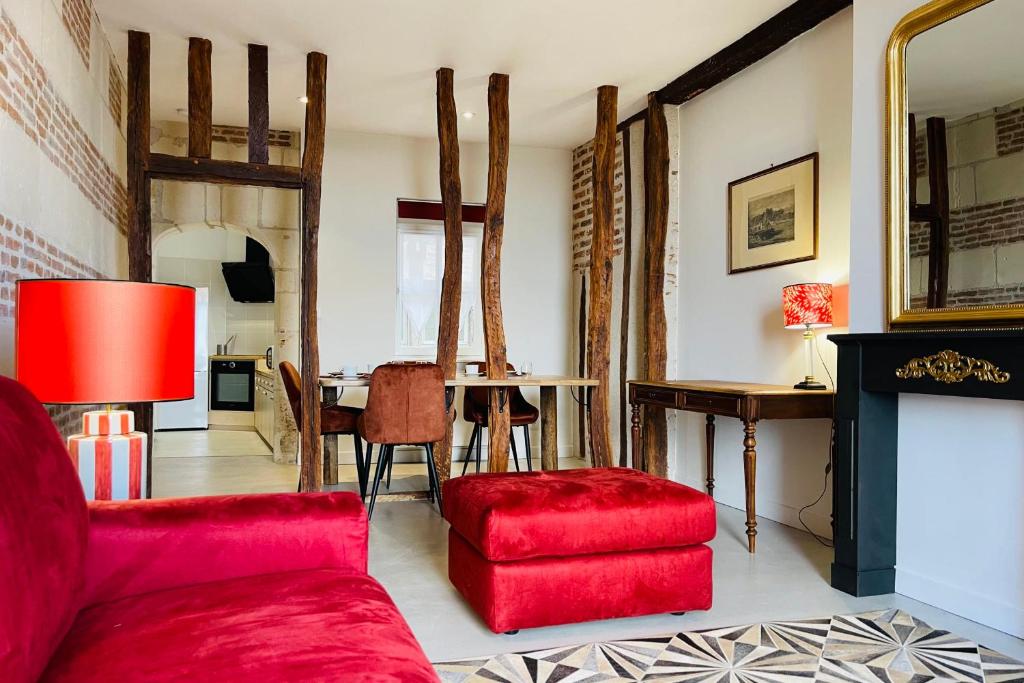 sala de estar con sofá rojo y mesa en Splendid apartment at the foot of the castle of Amboise - View of the Loir, en Amboise