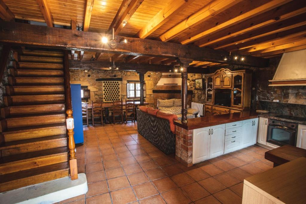 uma grande cozinha com tectos em madeira e uma bancada em La Casa de Consuelo 3 em Viérnoles