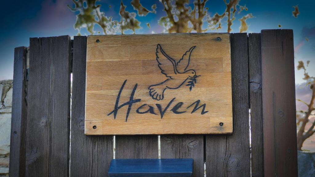 un cartello con un uccello su una recinzione di legno di Haven a Limassol