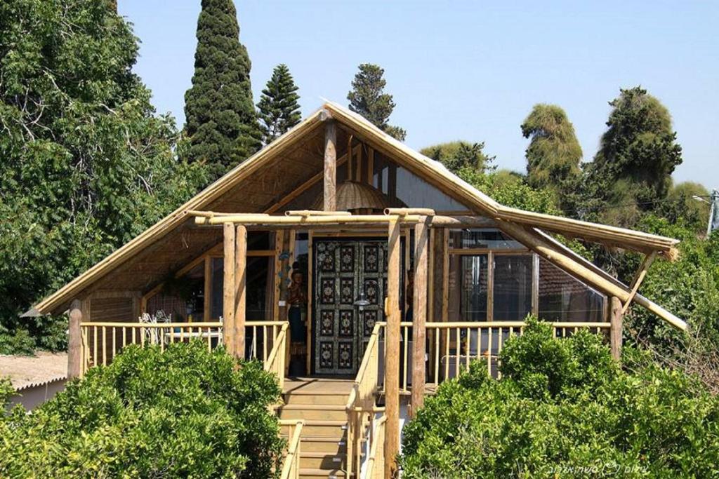 a log home with a porch and a door at ביקתפוז וקלמנטינה- מתחם בקתות וסוויטות עם ג'קוזי פרטי ובריכה משותפת in Liman