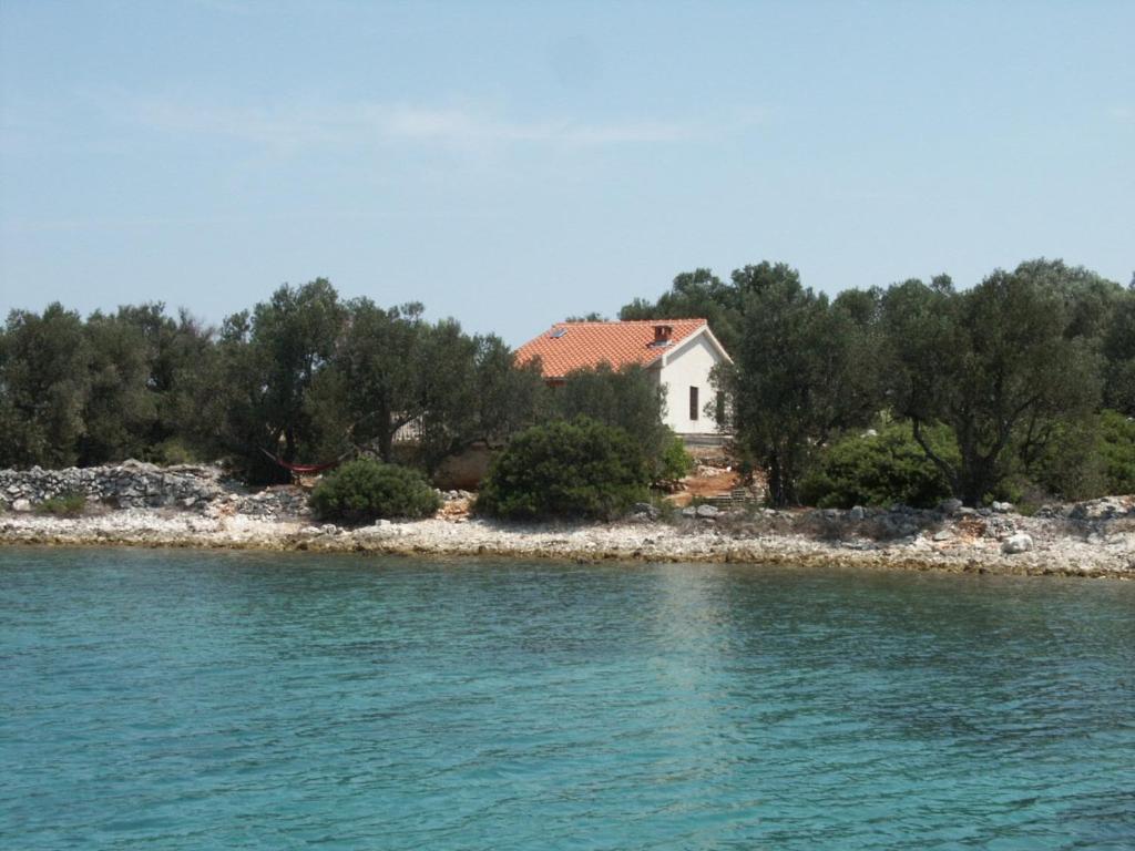 a house on the shore of a body of water at Secluded fisherman's cottage Krknata, Dugi otok - 399 in Žman