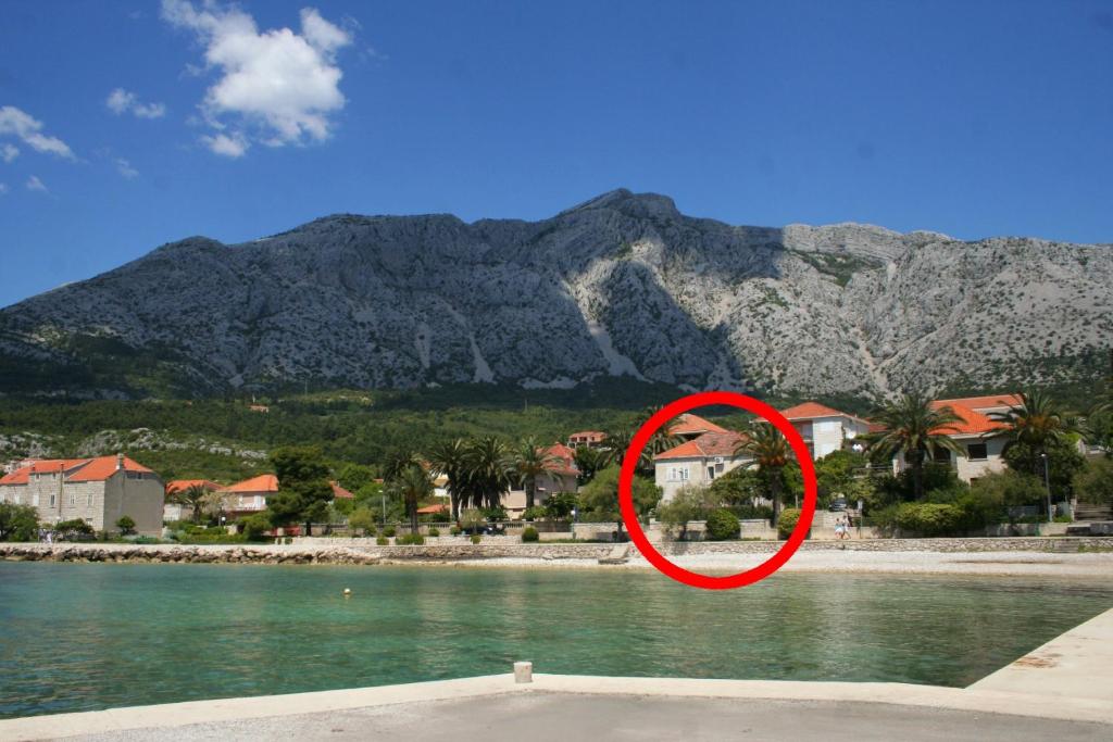 a red sign in front of a body of water at Apartments by the sea Orebic, Peljesac - 251 in Orebić