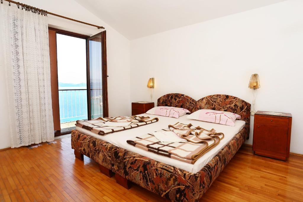 a bedroom with a large bed and a large window at Triple Room Trpanj 258a in Trpanj
