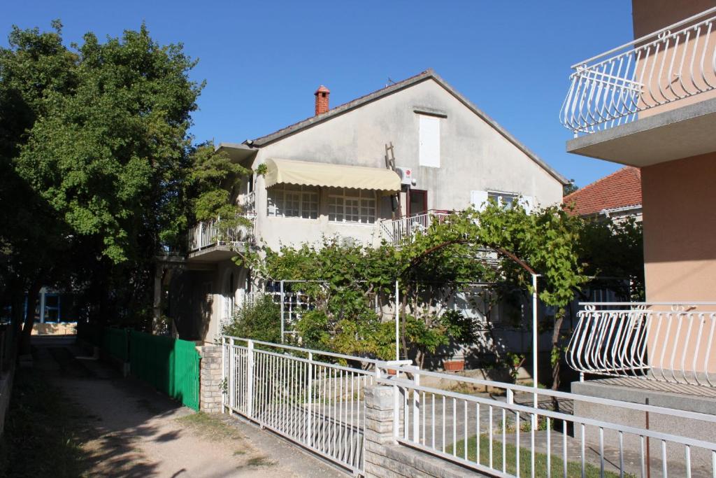 a white house with a fence in front of it at Apartments with a parking space Biograd na Moru, Biograd - 366 in Biograd na Moru