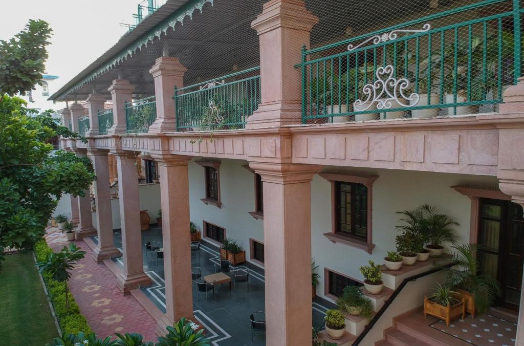un edificio de apartamentos con un balcón con plantas. en Hanuwant Niwas Jodhpur en Jodhpur