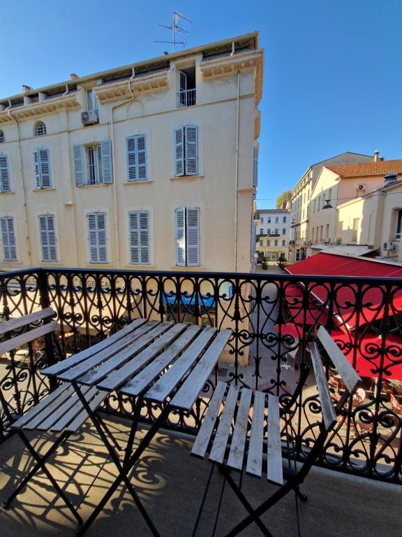 a picnic table on a balcony with a building at Hôtel La Villa Tosca in Cannes