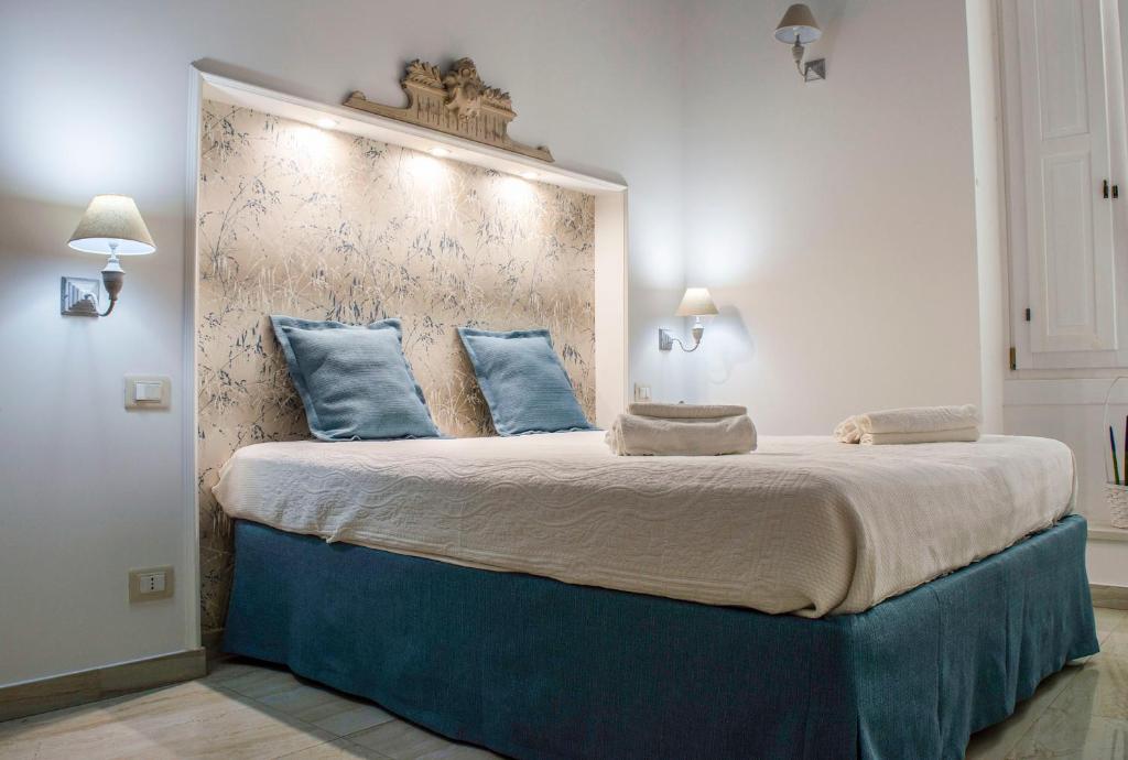 una camera da letto con un grande letto con cuscini blu di Casa Vacanze L'essenziale a Martina Franca