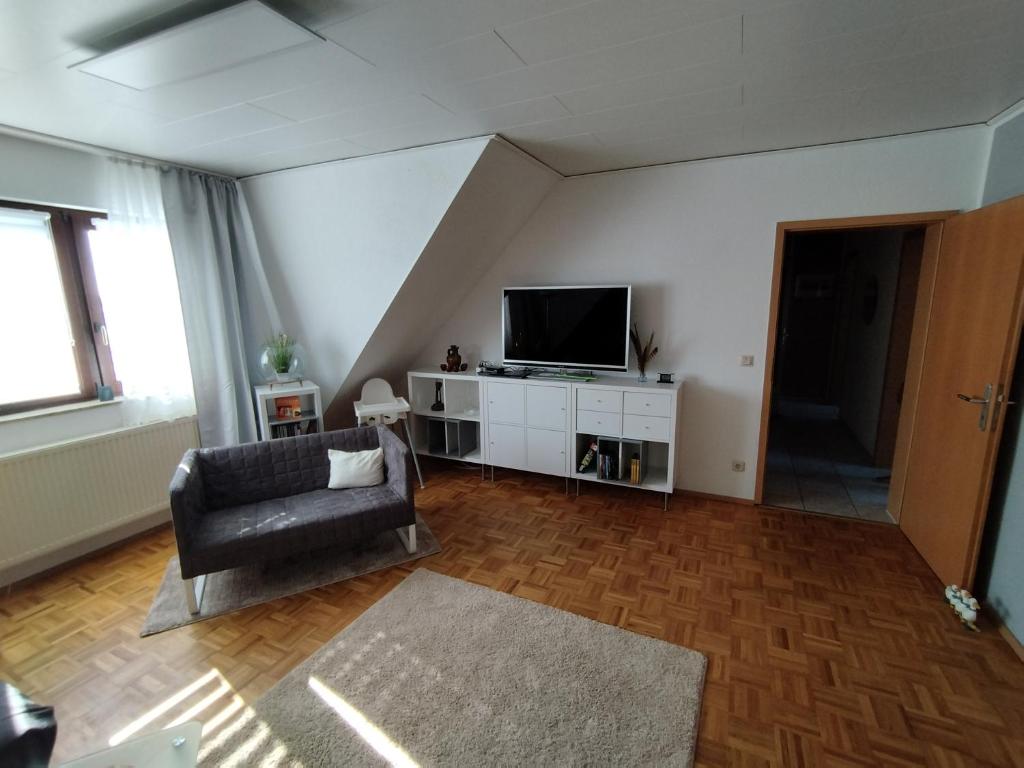 a living room with a chair and a television at Apartment Linss in Gebesee