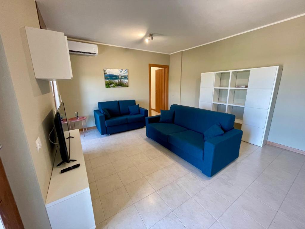 ein Wohnzimmer mit 2 blauen Sofas und einem TV in der Unterkunft Appartamento Giglio in Mantua