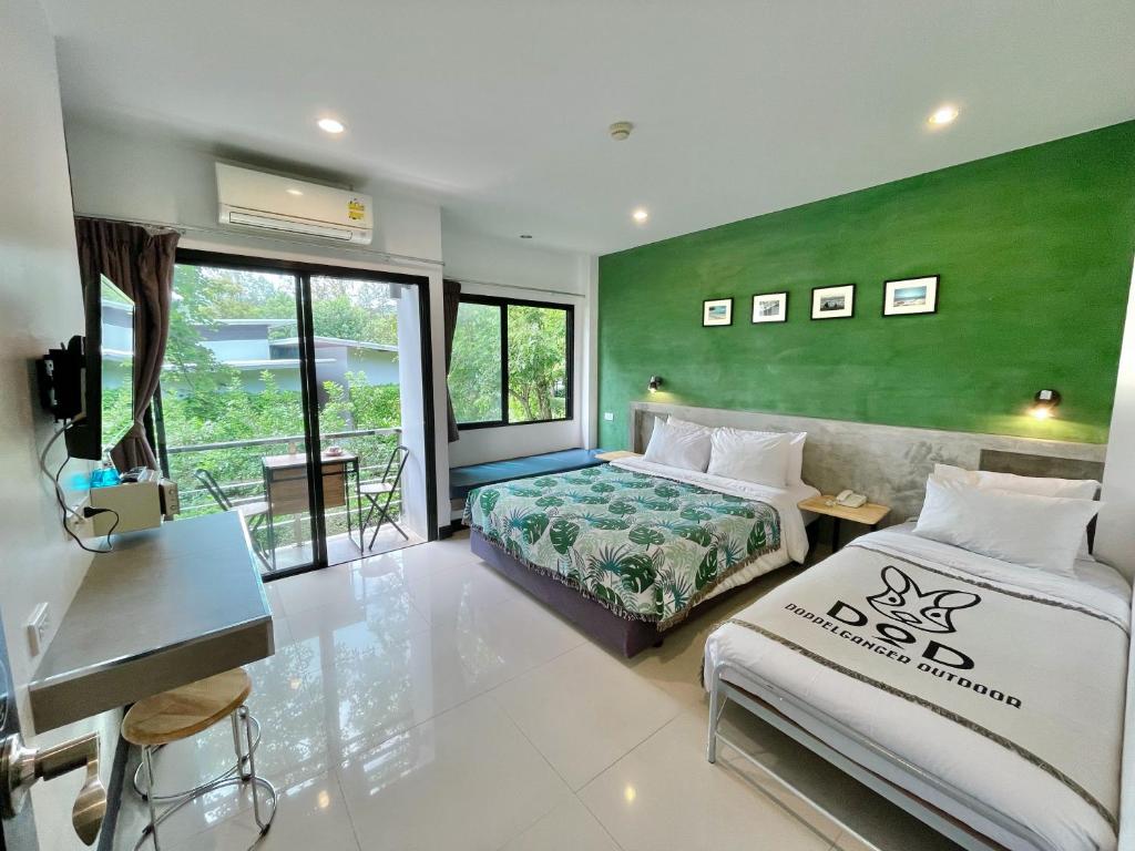 a bedroom with two beds and a green wall at Ideo Phuket Hotel - SHA Extra Plus in Nai Yang Beach