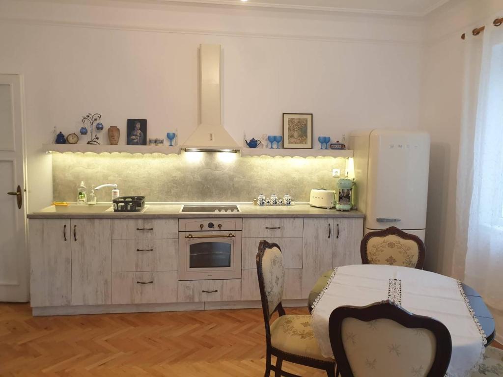 a kitchen with a sink and a refrigerator and a table at Апартамент BOHO CHIC 2 Free parking in Varna City