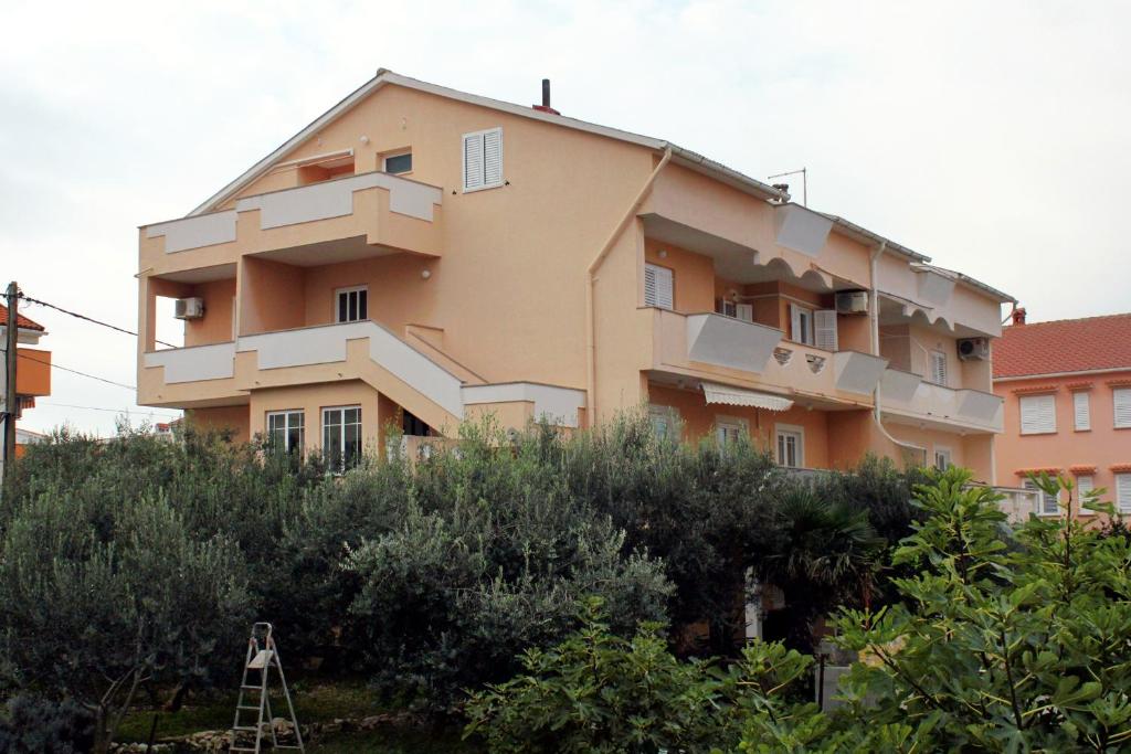 a large building on a hill with at Apartments with parking space Novalja, Pag - 9419 in Novalja