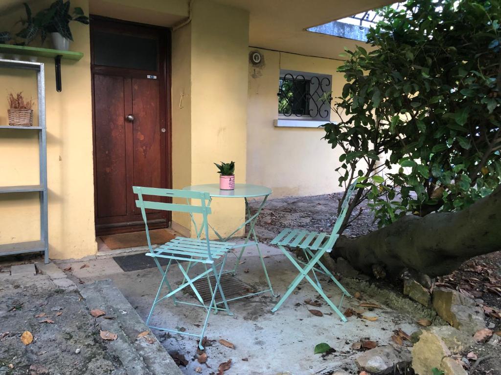 een tafel en twee stoelen voor een huis bij Au Cynorrhodon in Villeurbanne