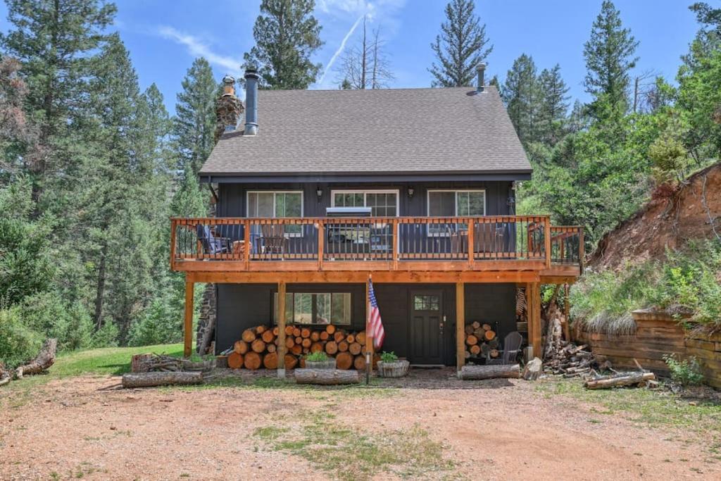 a house with a deck with a lot of logs at Cozy Mountain Cabin in Cascade in Cascade-Chipita Park