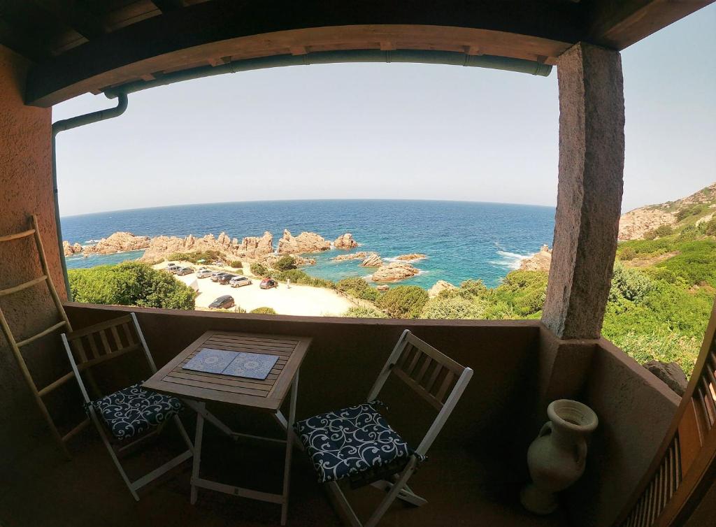 een kamer met een raam met een tafel en stoelen bij Apartmán Panoramico in Costa Paradiso