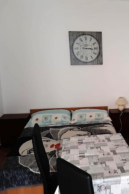 a bedroom with a bed and a clock on the wall at Studio Sukosan 14681c in Sukošan