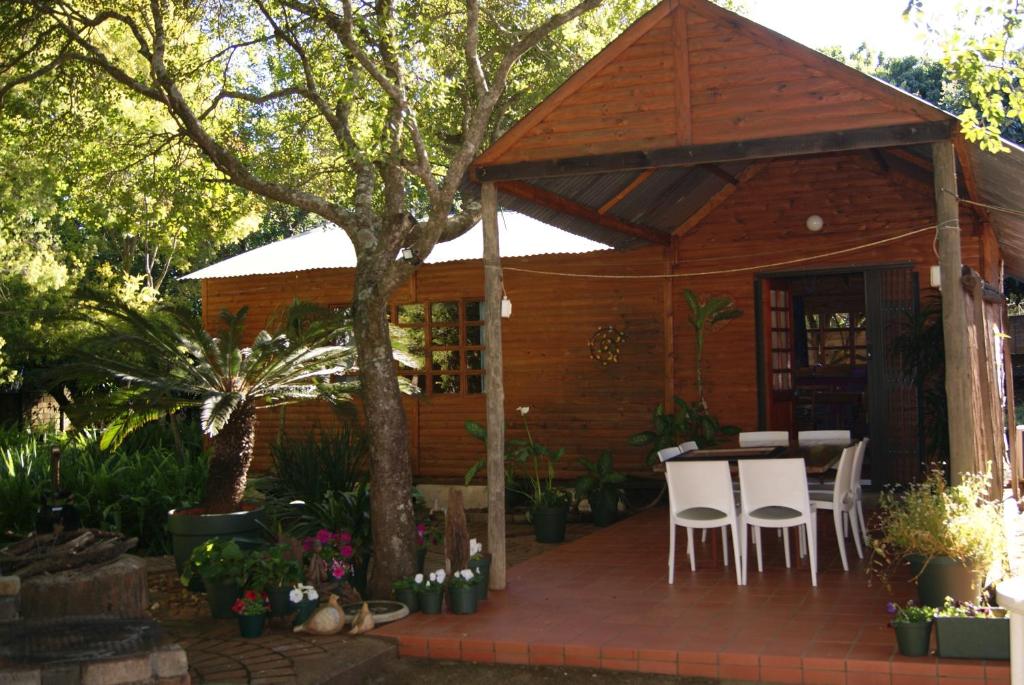a small wooden cabin with a table and chairs at Fern Cottage in Louis Trichardt